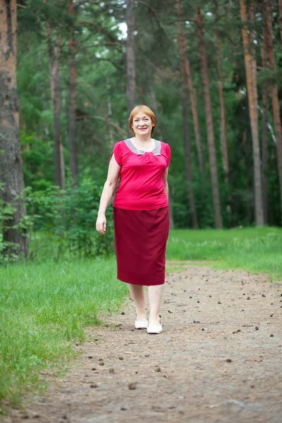 Kvinnan promenader i tallskogen — Stockfoto