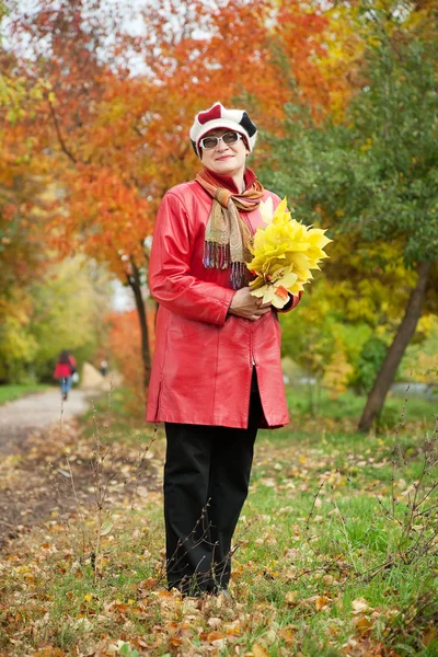 Mature woman in autumn park — Stock Photo, Image