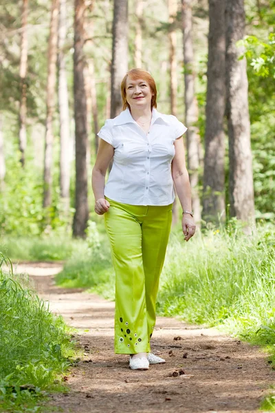 Walking mature woman in forest — Stock Photo, Image
