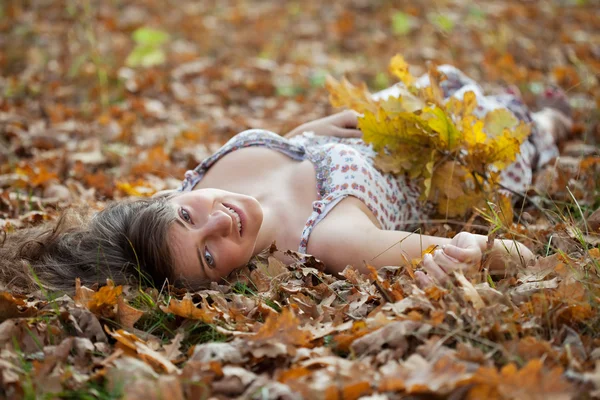 Menina está em folhas de carvalho — Fotografia de Stock