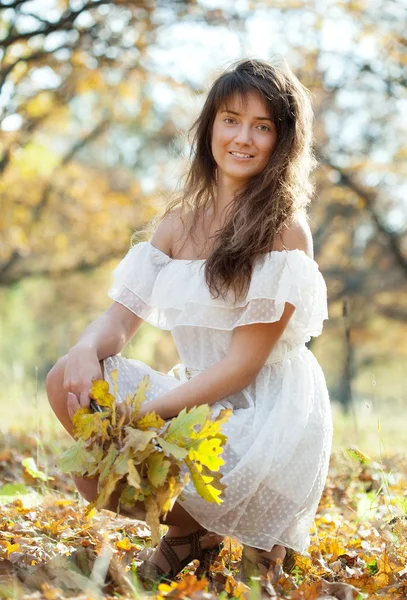Длинноволосая девушка с дубовой позой осенью — стоковое фото