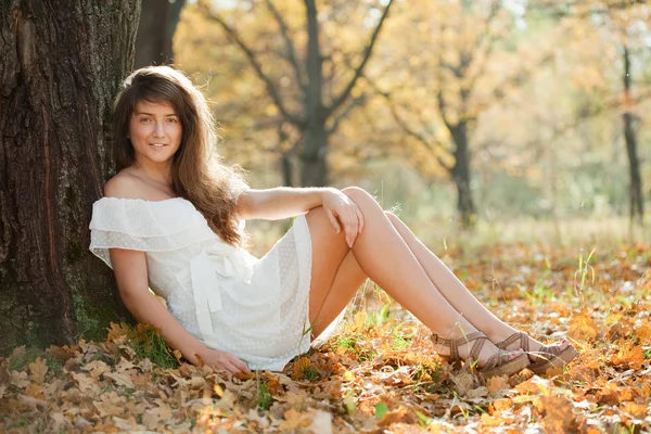 Menina em vestido branco no parque de outono — Fotografia de Stock