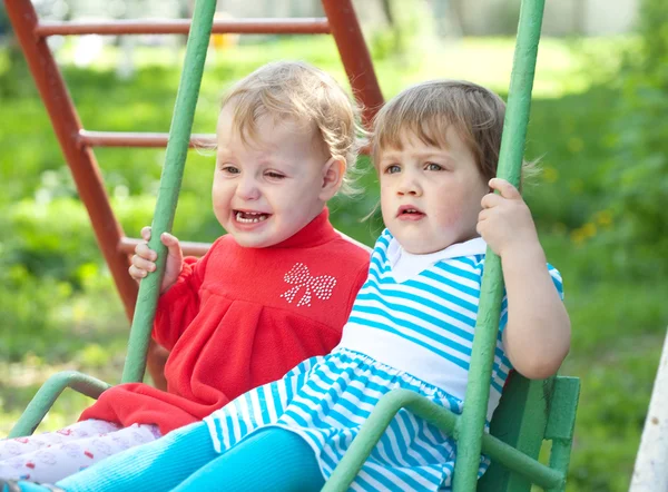 Two children on swings — Stock Photo, Image