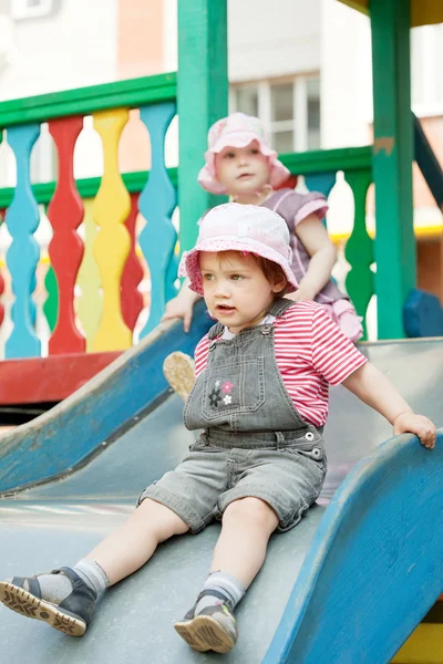 Duas crianças em slide — Fotografia de Stock