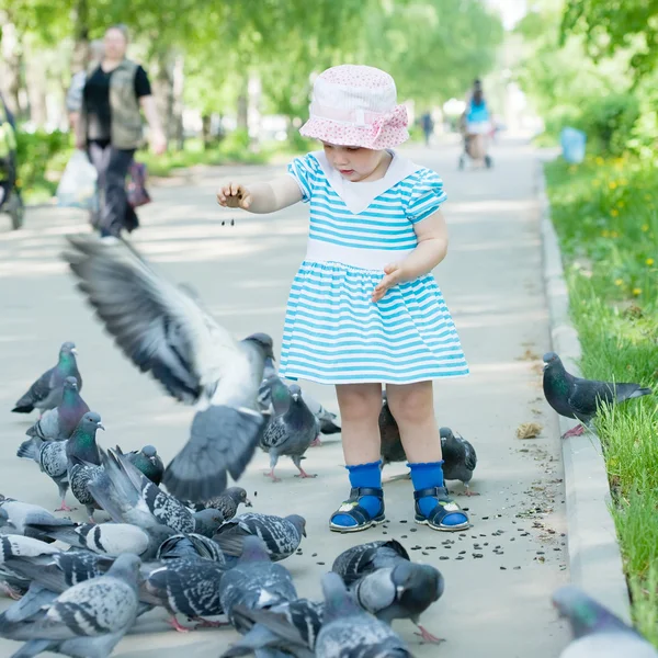 Chica de dos años alimentando palomas — Foto de Stock