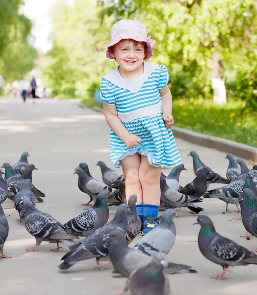 Menina feliz de dois anos brincando com pombas — Fotografia de Stock