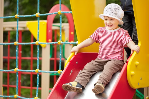 Happy two-year child on slide — Stock Photo, Image