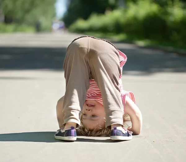 Chid upside down in park — Stock Photo, Image