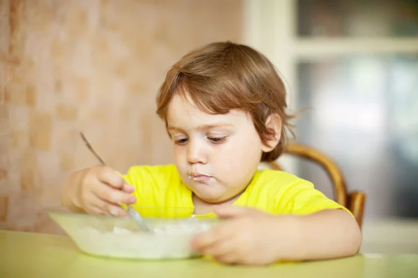 2 года ребенок сам ест из тарелки — стоковое фото