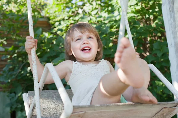Laughing girl on swing in summer — Stock Photo, Image