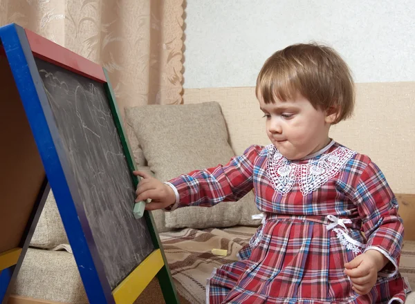 Kind vestigt op bord met krijt — Stockfoto