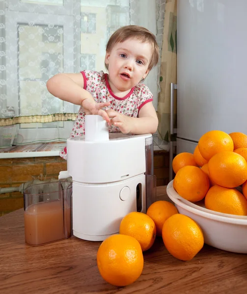 Малышка делает свежий апельсиновый сок — стоковое фото
