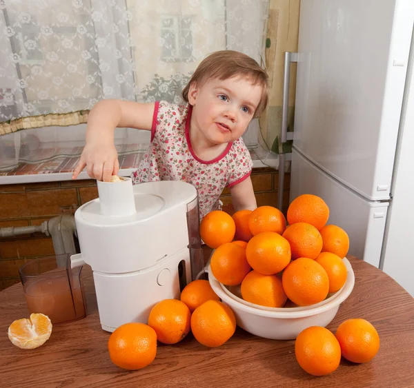 Bebé niña añadiendo naranja al exprimidor — Foto de Stock