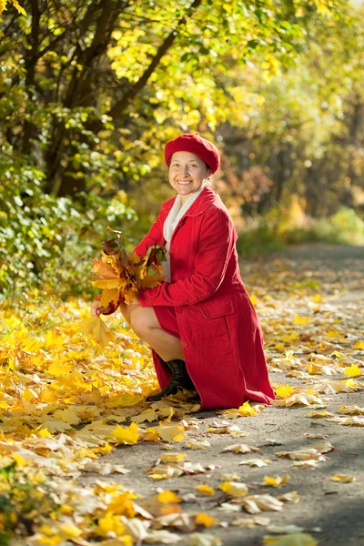 Šťastné zralá žena s javorovým kytička — Stock fotografie