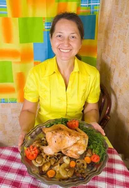 Женщина с приготовленным цыпленком — стоковое фото