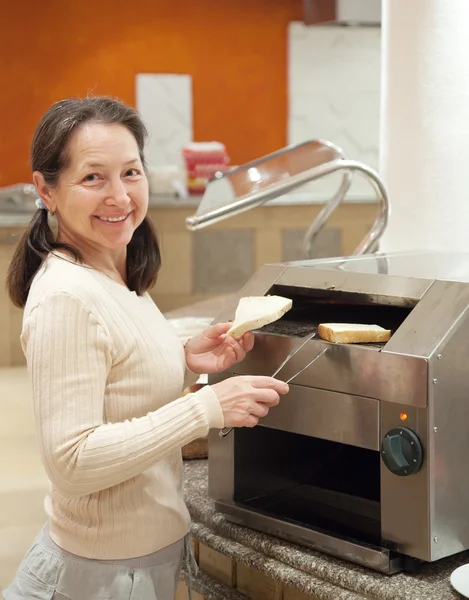 여자는 토스터기에 토스트를 만드는 — 스톡 사진