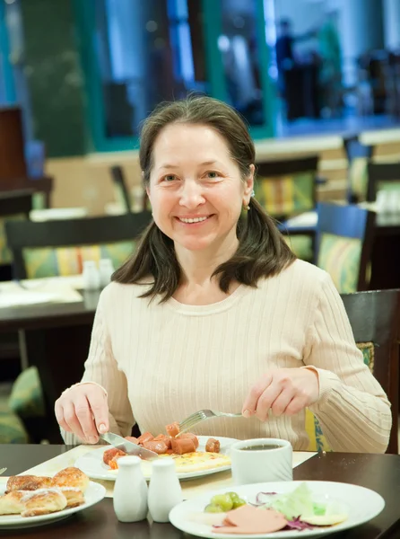 Gammal kvinna som äter frukost — Stockfoto