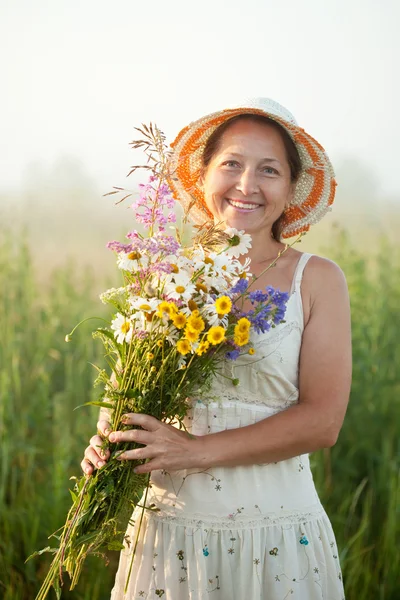Mulher madura reúne ervas — Fotografia de Stock