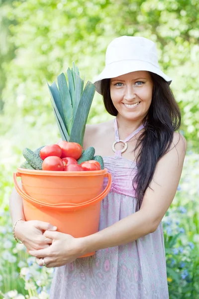 Happy woman holds vegetables harvest — Stock Photo, Image