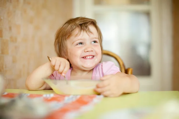 Child eats with spoon Royalty Free Stock Images