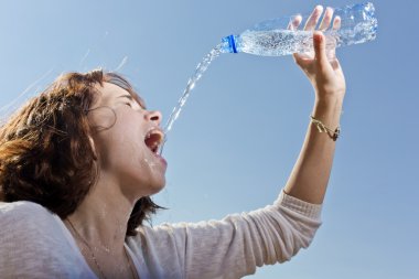 The girl pours water from a bottle clipart