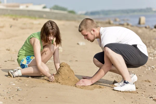Famiglia che fa un castello di sabbia — Foto Stock