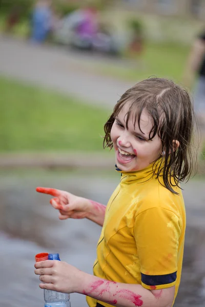 Девушка с размазанными красками смеется руками — стоковое фото