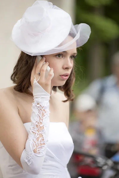 Het meisje in een witte jurk spreekt via de telefoon — Stockfoto
