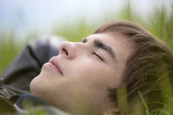 Chlap ležící na trávě na povaze — Stock fotografie