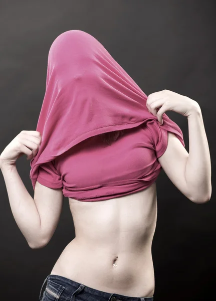 Молодая женщина с закрытым лицом и пирсинг на животе — стоковое фото