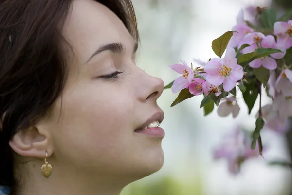 女人碰在树上的花 — 图库照片