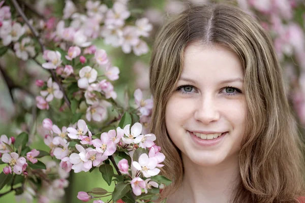 Una joven en un huerto de manzanas en plena floración . — Foto de Stock