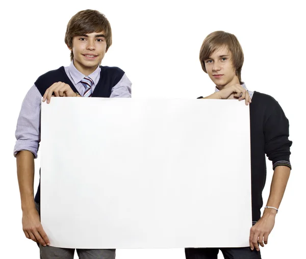 Двоє молодих хлопців тримають порожній аркуш / білий плакат — стокове фото