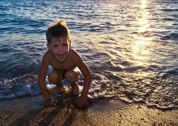 Pojke och havet i solnedgången — Stockfoto