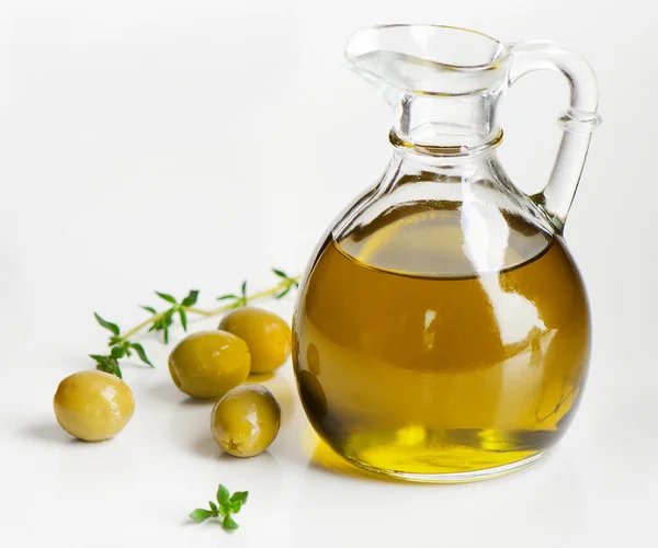 Оливковое масло и зеленые оливки — стоковое фото
