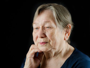 Sad old senior woman looking down and crying clipart