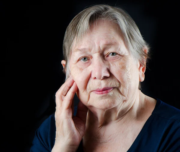 Trieste oude senior vrouw op zoek naar beneden en huilen — Stockfoto
