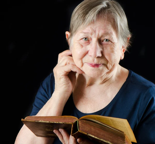 Пожилая улыбающаяся женщина с книгой — стоковое фото