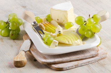 Cheese and grapes on wooden platter