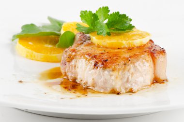 Fried pork steak with orange slice clipart