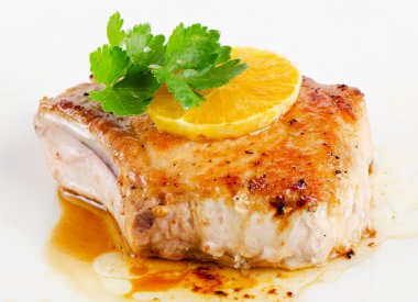 Fried pork steak with orange slice clipart