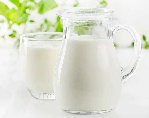 Jarra de vidrio y vaso con leche —  Fotos de Stock