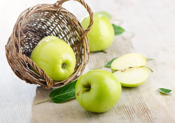 Čerstvá jablka do koše na dřevěný stůl — Stockfoto