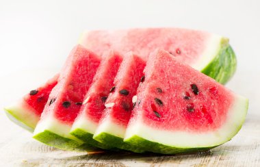 Slices of watermelon on wooden table clipart