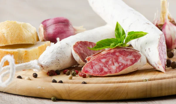 Salami sliced on wooden table — Stock Photo, Image