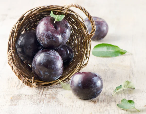 Group of plums in basket — Stock Photo, Image