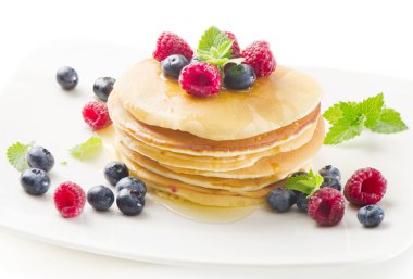 Pancakes with raspberries and blueberries isolated on white clipart