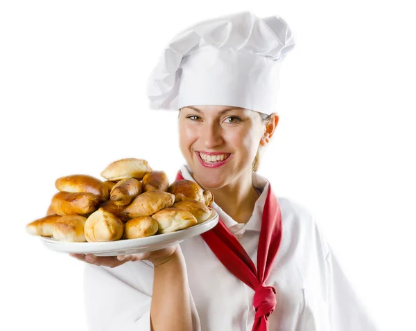 Молодая женщина-повар держит тарелку с пирогами — стоковое фото