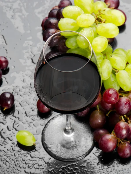 Glass of red wine with grapes — Stock Photo, Image