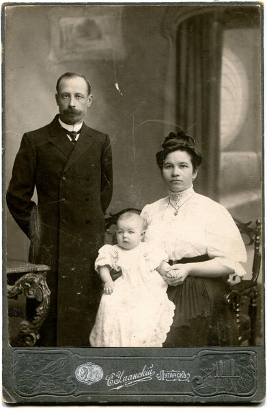 RUSSIA - CIRCA end of the XIX - the beginning of XX century: An antique photo shows family with one child, Lugansk, Russian Empire, Ukraine Russian text: Umanskiy (name of photographer), Lugansk